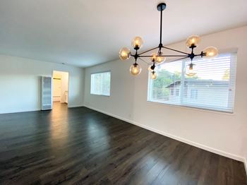 Stunning living room with hardwood floors, modern lighting, and large window